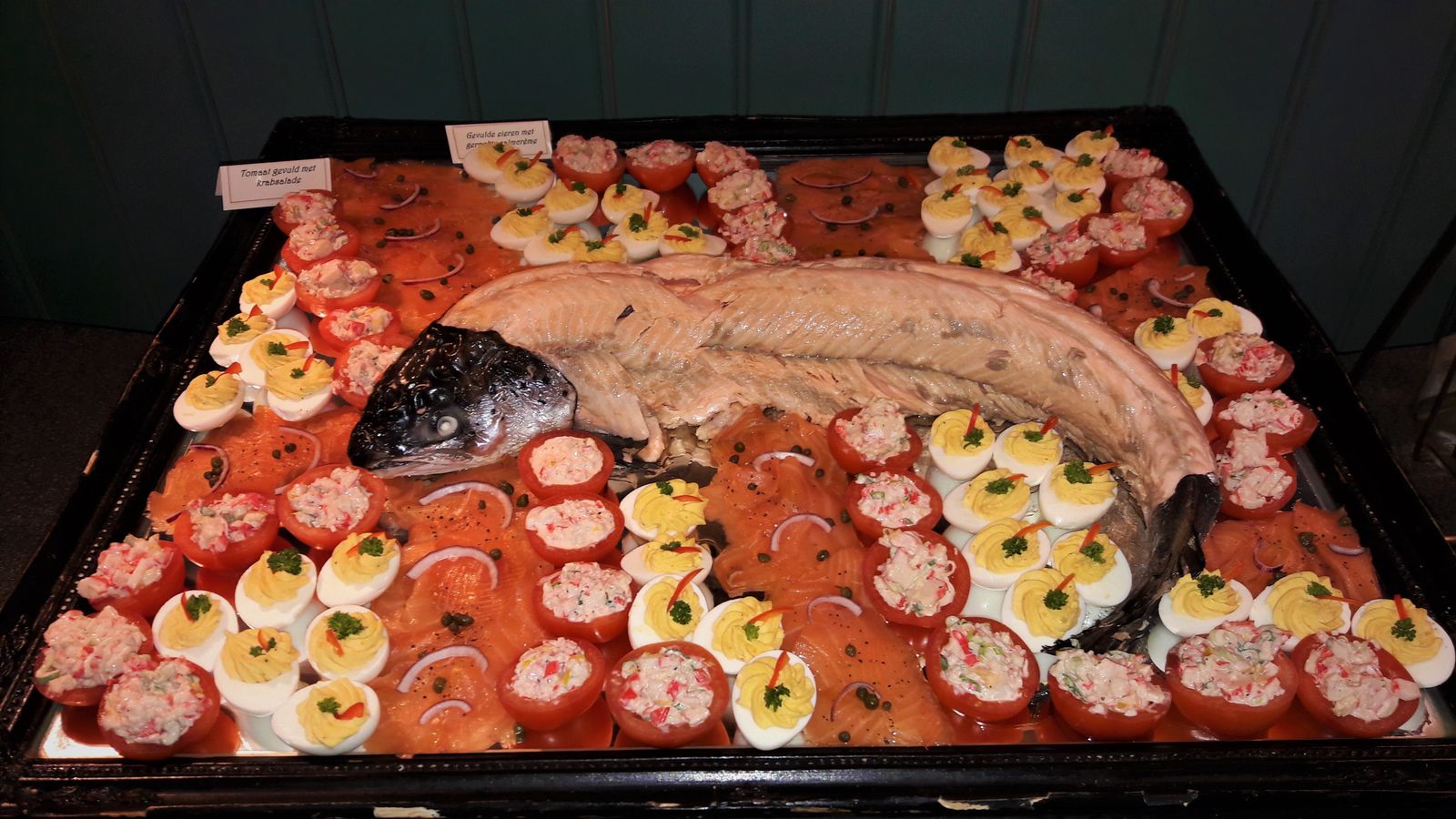 Schaal met zalm, gevulde eieren en tomaatjes van het buffet
