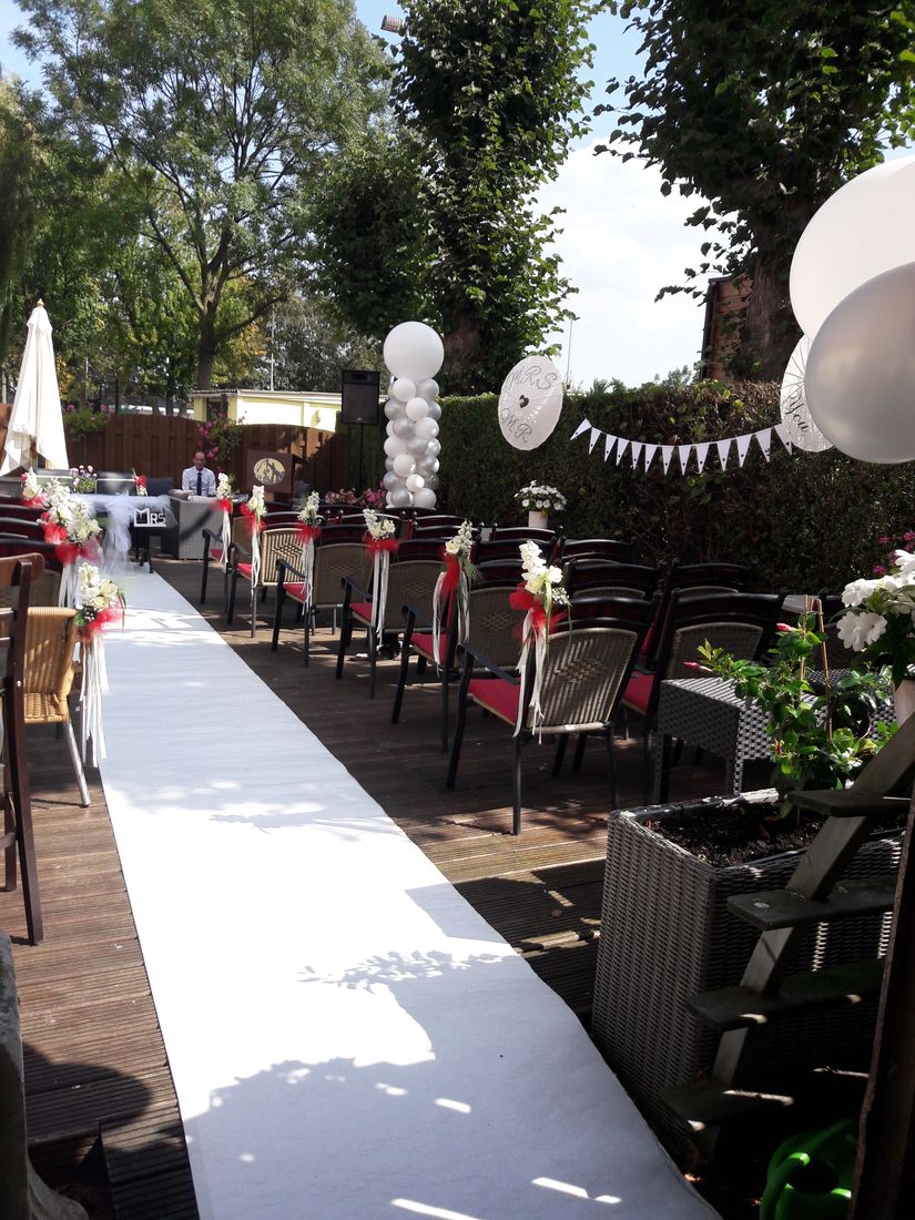 Stoelen met bloemen langs de witte loper