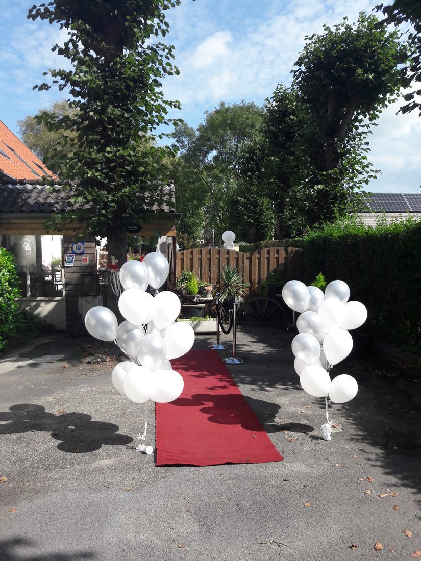 Rode loper met ballonnen bij de ingang