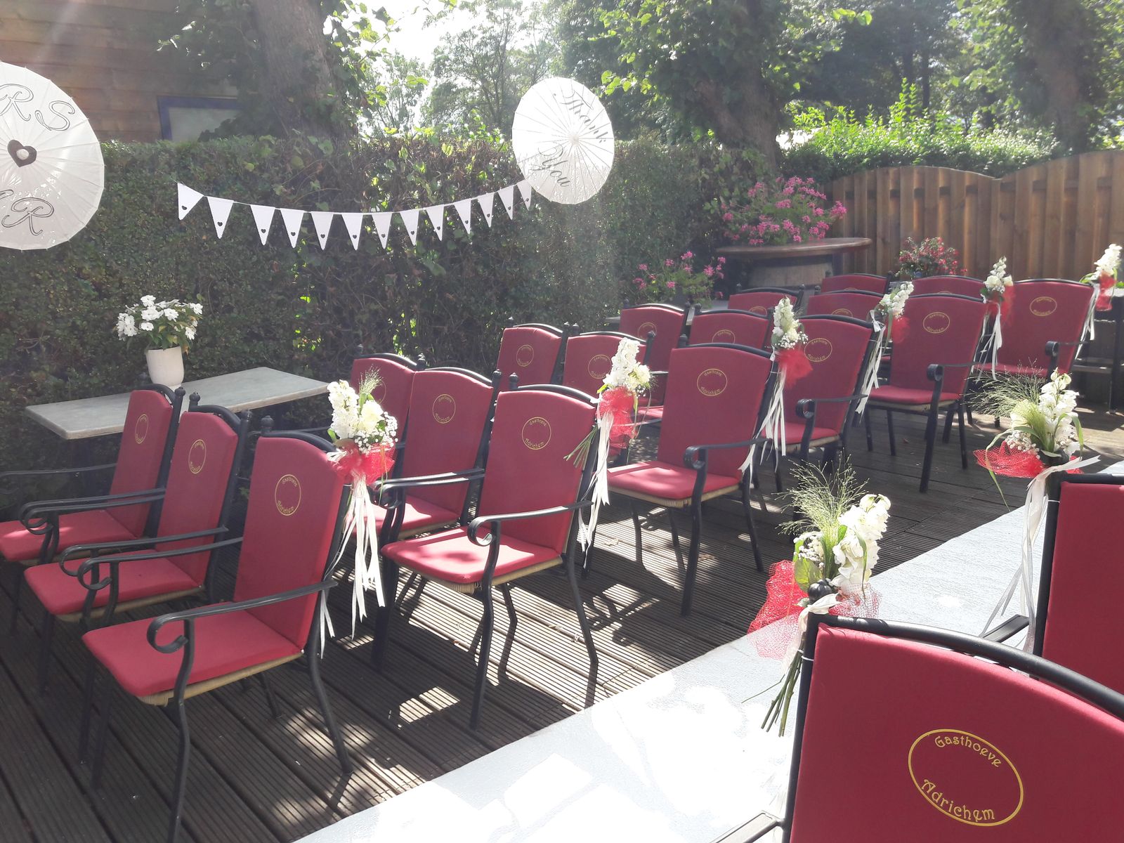 Terras ingericht voor de huwelijksceremonie met witte loper